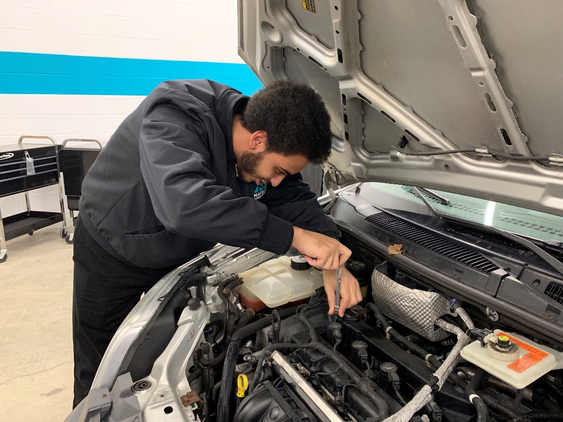 An automotive technician working efficiently on a car to make more money.